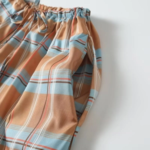 Relaxed fit plaid lantern pants featuring elastic drawstring waist and side pockets