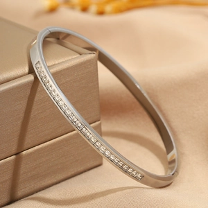 Detailed macro view of silver titanium steel bangle with sparkling crystal inlay on jewelry box