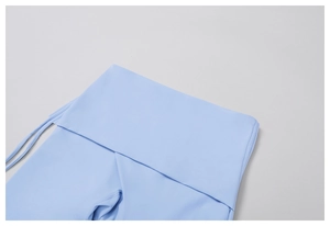 Detail of light blue high waist flare yoga pants with cross-over waist and side drawstring
