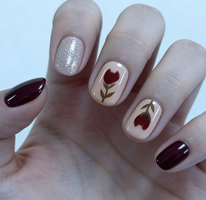Detail of matte rose pink and burgundy press-on nails with silver glitter and tulip art