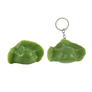 Green PVC artificial dumpling keychain with realistic textured dough surface and metal ring