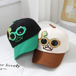 Détail de casquettes de baseball pour enfants avec dinosaures et visières colorées