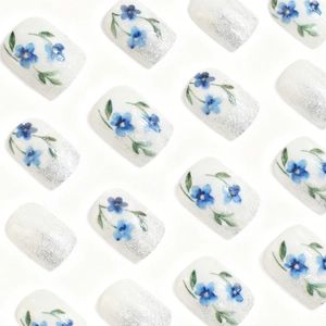 Floral press-on nails featuring blue flowers and silver glitter gradient finish