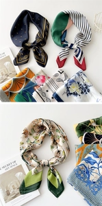 Detailed close-up of multiple printed silk scarves next to a fashion art magazine