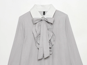 Detail of grey striped shirt featuring a white collar and large matching bow tie