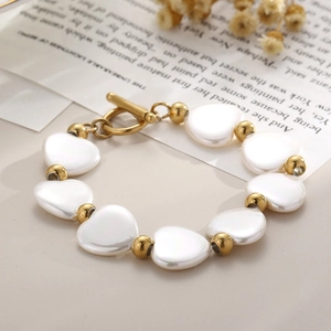 Détail du bracelet en nacre en forme de cœur avec fermoir OT doré et décor vintage