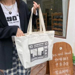 Close-up of cream canvas tote bag with Brick Lane Bookshop print on shop background