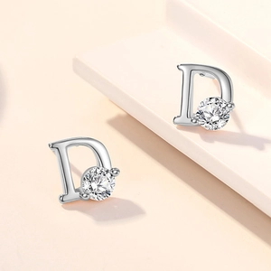 Vue rapprochée des boucles d'oreilles lettre D en argent avec un grand zircon cubique