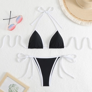 Flat lay of black and white string bikini set with beach hat and gradient sunglasses