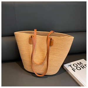Detail of hand-woven cotton tote bag featuring premium brown leather handles and stitching