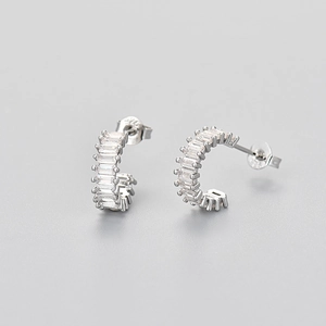 Detail view of silver stud earrings with baguette-cut cubic zirconia and butterfly backings