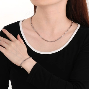 Ensemble collier et bracelet en acier argenté avec maillons trombone sur un mannequin