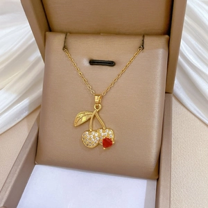 Detailed close-up of a sparkling cherry pendant necklace with red heart stone and zircons