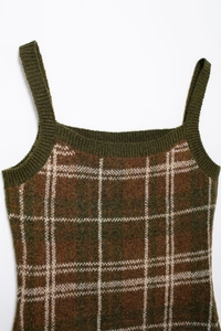 Close-up of vintage knit vest with plaid pattern and green ribbed edges details