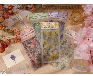 Flat lay of retro PET flower stickers with dried plants in a vintage natural setting