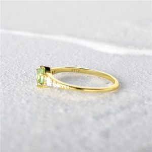 Detailed close-up showing S925 silver stamp and light green gemstone on a gold ring