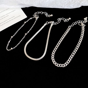 Detailed view of silver-tone triple chain set featuring snake, bead, and curb chain links
