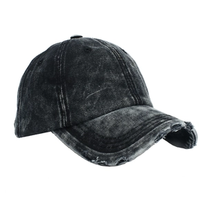 Detailed close-up of distressed denim baseball cap showing vintage frayed edges and texture