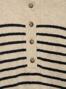 Gros plan du pull en tricot rayé beige avec quatre boutons marron et texture douce