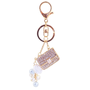 Golden camellia bag keychain with sparkling rhinestones and elegant pearls