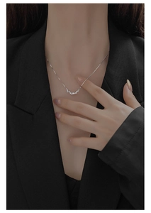 Close-up of minimalist S925 silver smiley necklace with zircons on a professional suit