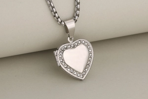 Detail view of a silver heart locket pendant with sparkling crystals and a box chain