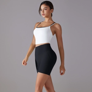 Detail of white sports top with black piping and high-waist black fitness shorts