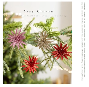 Close-up of glittery star Christmas tree decorations hanging on green pine branches