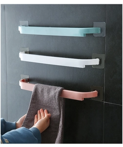 Three adhesive towel racks in blue, white, and pink mounted on a dark grey tiled wall
