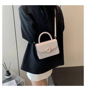 Chic cream small crossbody bag with gold round buckle shown on model with shoulder strap