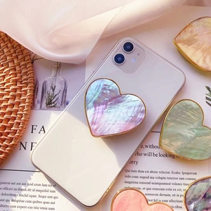 Dettaglio del supporto telefono a cuore con texture a conchiglia e bordo dorato