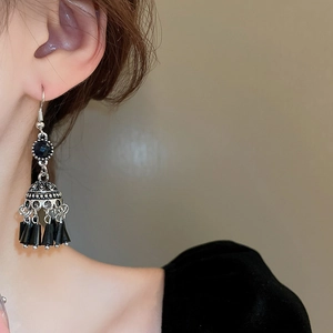 Dettaglio di orecchini etnici vintage in argento con perline nere sulla modella