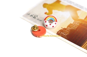 Close-up of cute cartoon donut brooch with rainbow design and metal butterfly clutch pin