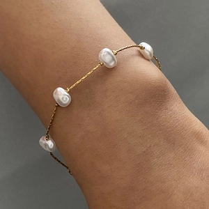 Baroque pearl bracelet in 18K gold plated stainless steel on a model's wrist