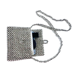 Macro detail of silver beaded crossbody bag with white zipper and metallic beads