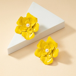 Detail of yellow petal earrings with pearl centers on minimalist geometric blocks