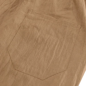 Detail view of the reinforced pentagonal pocket and linen texture on khaki casual shorts