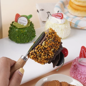 Modelo realista de tarta de mousse de chocolate con nueces y cereza en una pala