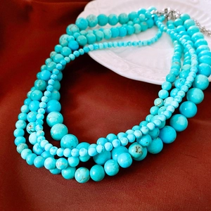 Détail de collier à perles turquoise multicouches avec textures naturelles et fermoir argent