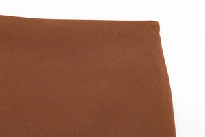Détail du tissu en sergé marron et tissage fin pour l'ensemble jupe et haut