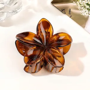 Close-up of amber flower hair claw clip with transparent gradient resin and metal spring