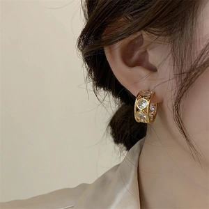 French vintage gold C-shaped earrings with clear cubic zirconia on model