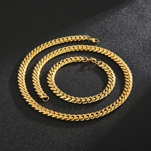 Detailed set of 8mm 18k gold plated Cuban chain necklace and bracelet on dark surface