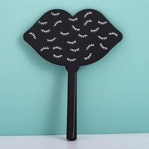 Detail of black lip-shaped handheld mirror featuring a unique white closed eye pattern