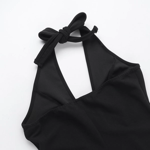 Détail de la robe dos nu noire avec un élégant nœud papillon et texture du tissu raffinée