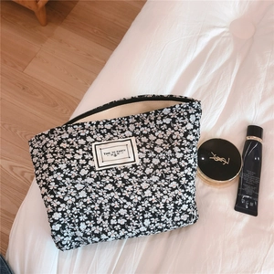 Macro detail of floral cotton pouch with zip closure and white fabric label