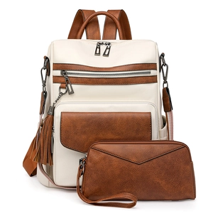 Close-up of retro backpack and envelope clutch set with tassels and PU leather texture