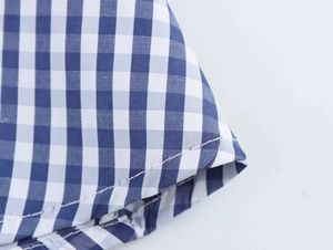 Detailed close-up of blue and white plaid fabric texture with neat stitching craftsmanship