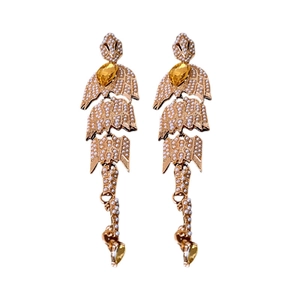Gold fishbone drop earrings with white pearls and amber teardrop gems on white background