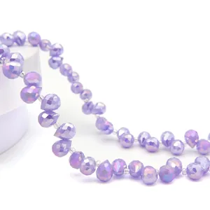 Macro view of faceted purple teardrop crystal beads with iridescent AB coating